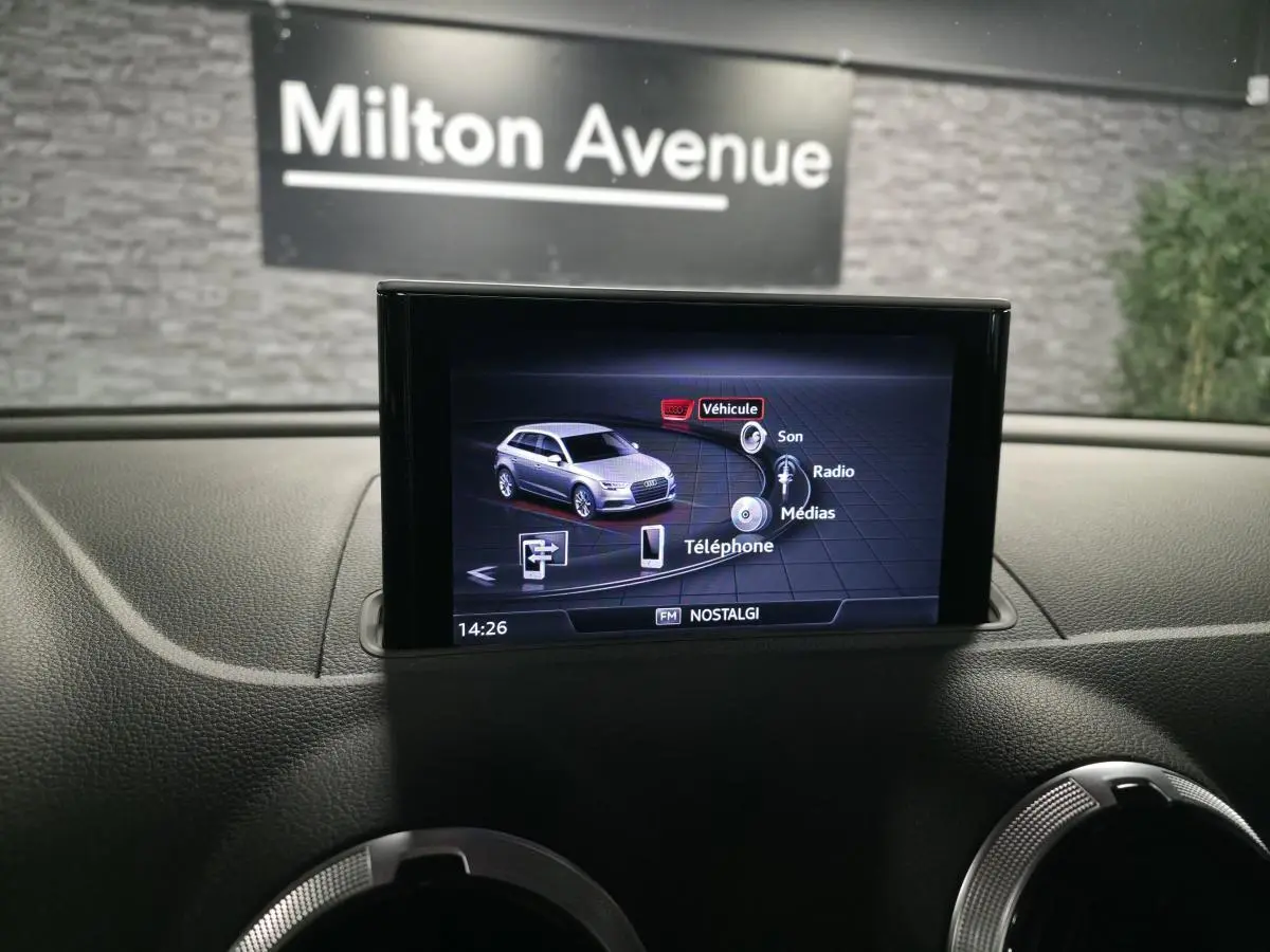 Écran central de l'Audi A3 Sportback affichant le menu multimédia, intérieur noir avec tableau de bord texturé.