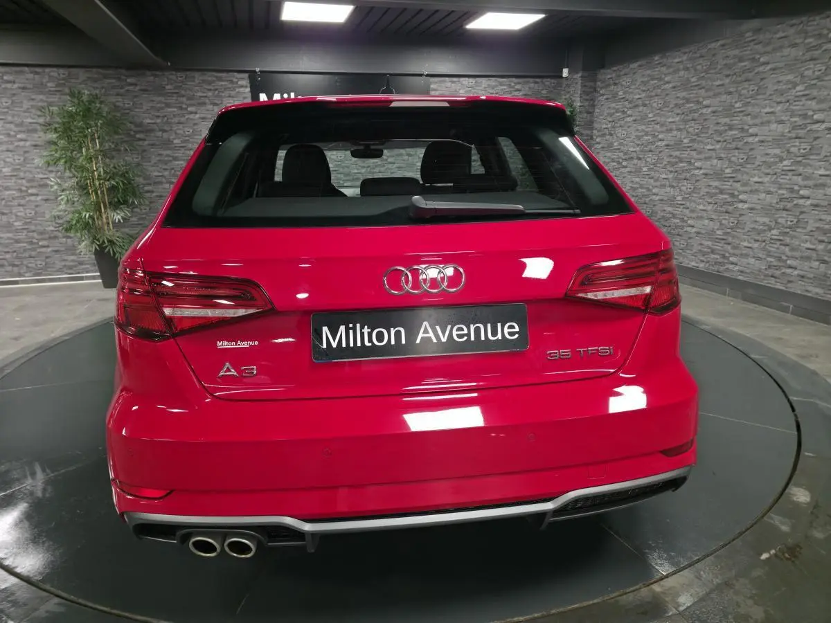 Vue arrière d'une Audi A3 Sportback rouge avec double sortie d'échappement et becquet de pavillon S line.