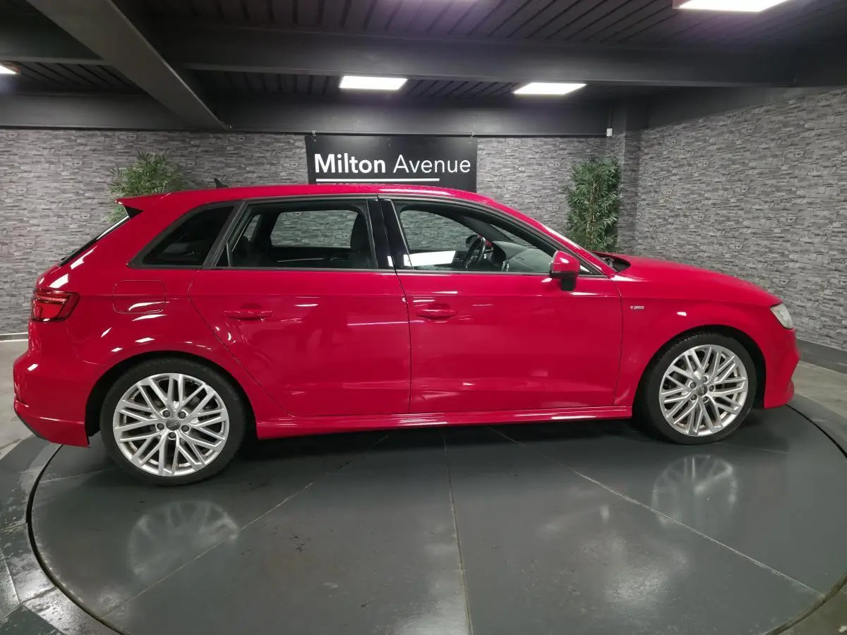 Audi A3 Sportback rouge vue de profil côté gauche, avec jantes Audi Sport 10 branches et becquet S line.