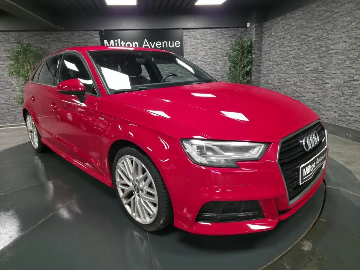 Audi A3 Sportback rouge vue 3/4 avant droit avec jantes Audi Sport 10 branches et calandre noir brillant.