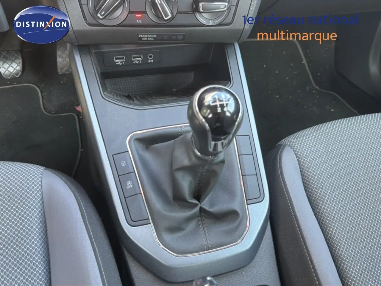 Vue rapprochée de la console centrale avec levier de vitesses manuel du SEAT Arona gris urbain, intérieur tissu gris.