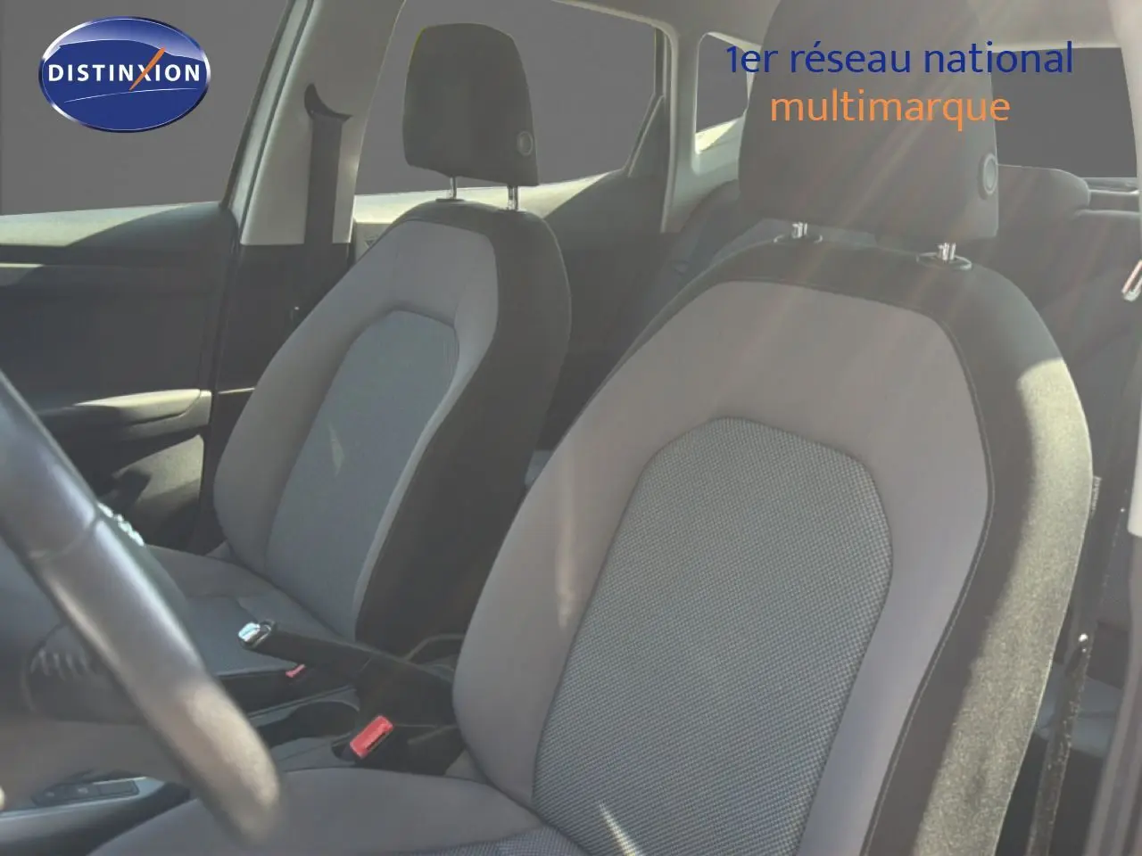 Vue intérieure rapprochée des sièges avant en tissu gris du SEAT Arona 2018, avec volant partiellement visible.