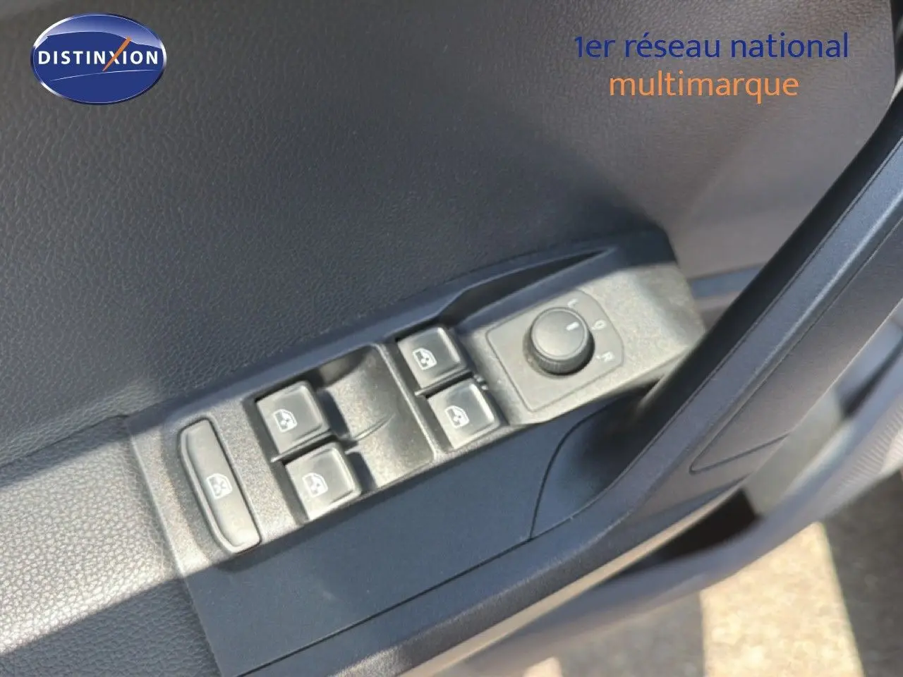 Gros plan sur les commandes des vitres et rétroviseurs côté conducteur d’un SEAT Arona gris urbain avec toit noir.