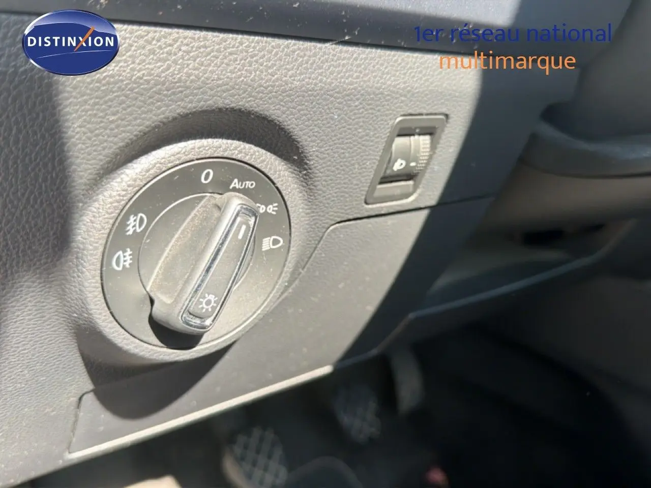 Gros plan sur le bouton de commande des phares dans l’habitacle d’un SEAT Arona gris urbain toit noir.