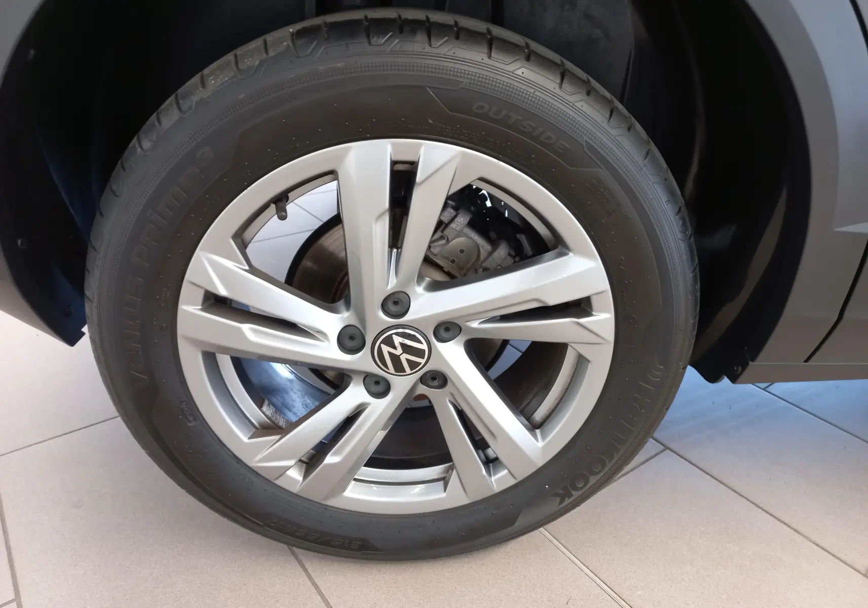 Gros plan sur la jante alliage 17 pouces Valencia du Volkswagen T-Roc gris Indium, avec écrous antivol visibles.