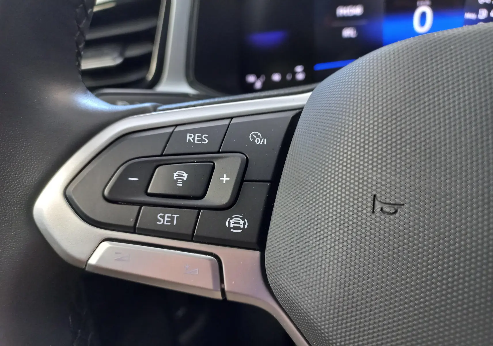 Gros plan sur les commandes au volant côté gauche du Volkswagen T-Roc 2025, finition VW Edition, intérieur noir.