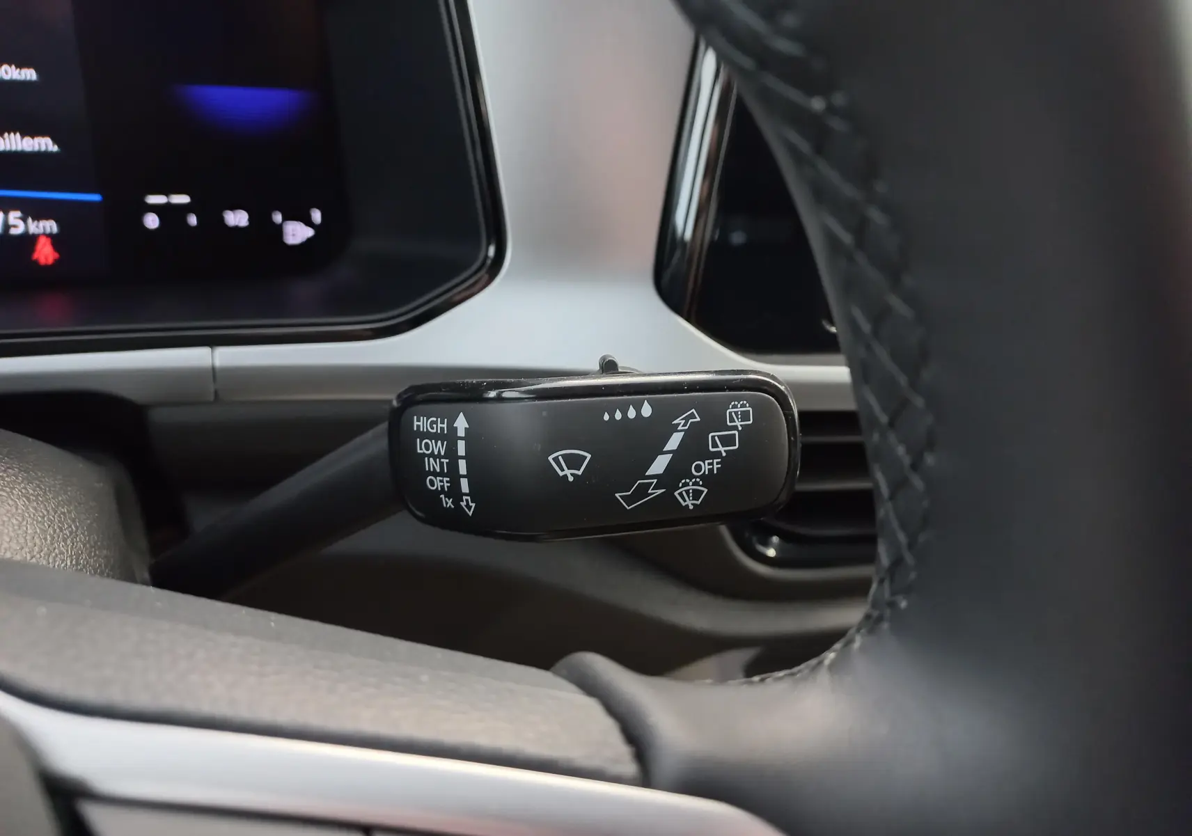 Gros plan sur la commande d'essuie-glace côté droit du volant dans l'habitacle du Volkswagen T-Roc Gris Indium.