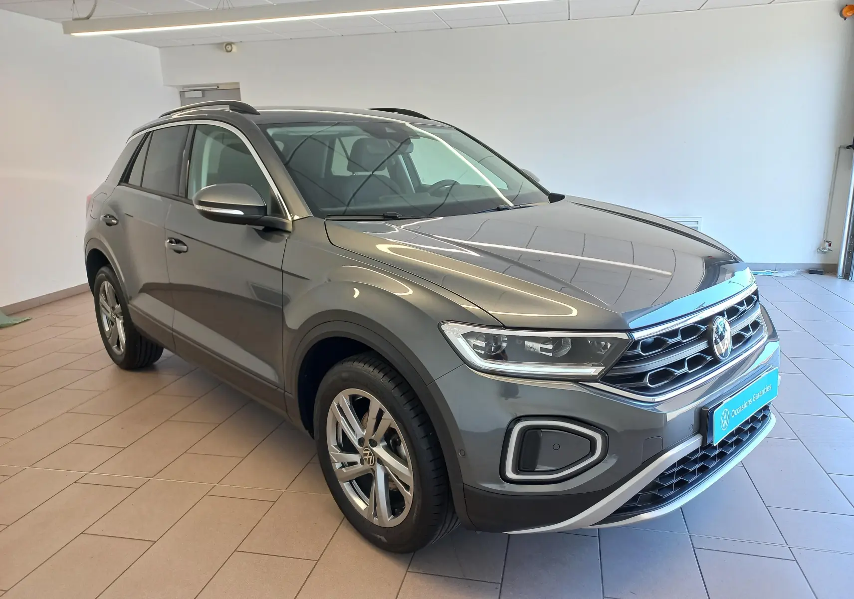 Volkswagen T-Roc gris Indium en 3/4 avant droit, avec jantes alliage 17’’ Valencia et détails chromés.