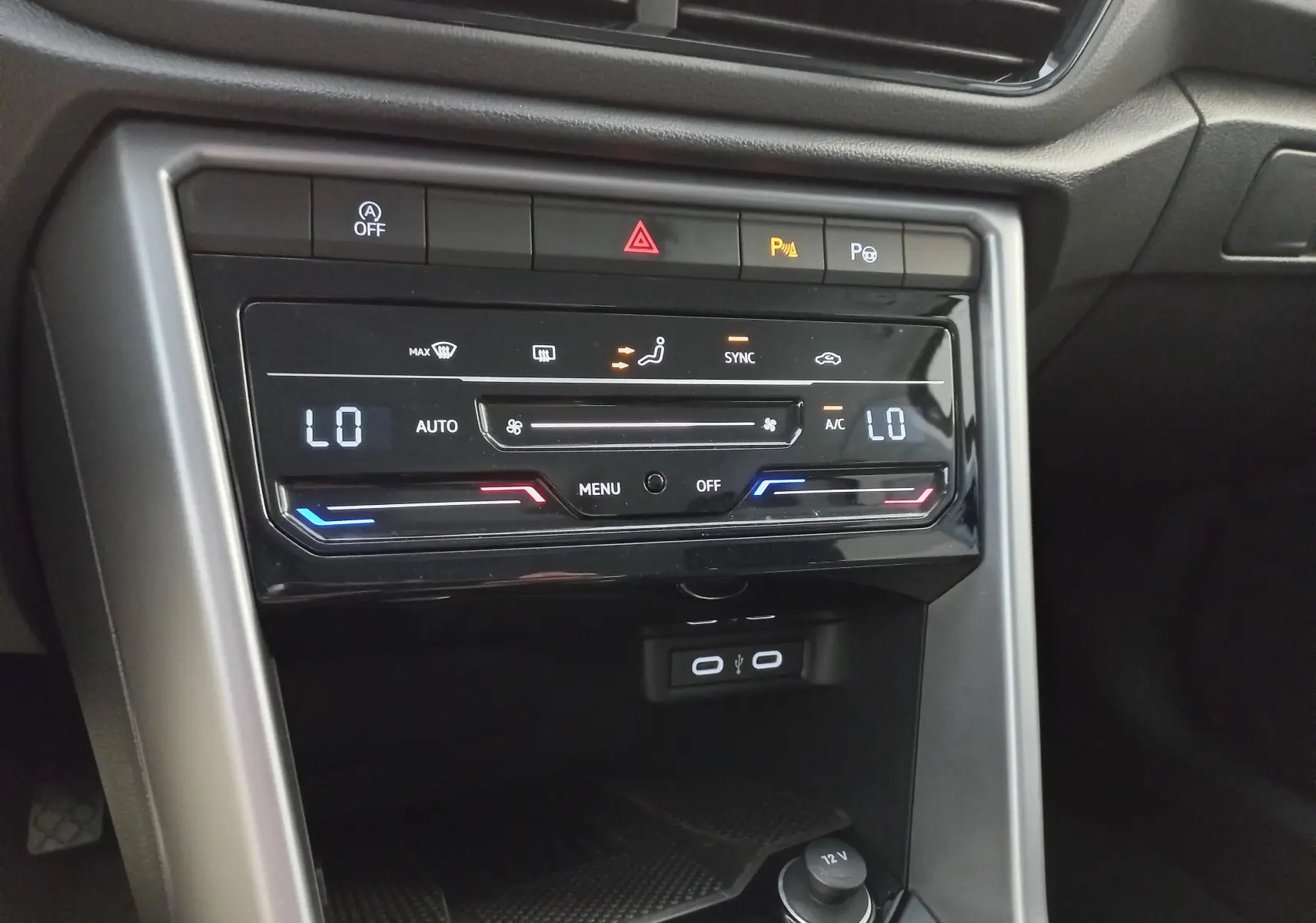 Vue rapprochée de la console centrale du Volkswagen T-Roc 2025, affichant la climatisation digitale et les ports USB.