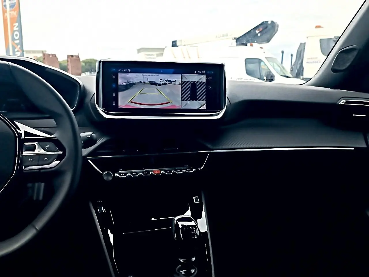 Vue intérieure du tableau de bord de la Peugeot 2008 1.2 100 Allure, avec écran tactile affichant la caméra de recul.