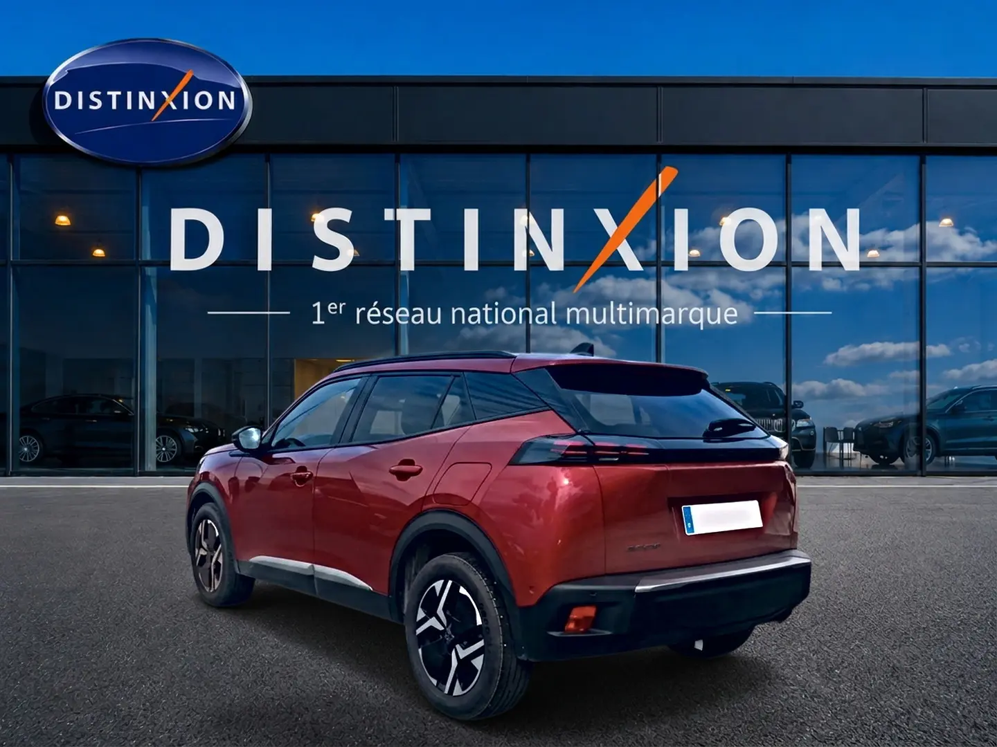 Peugeot 2008 rouge elixir vue 3/4 arrière droit, avec jantes alu et feux arrière LED, devant showroom Distinxion.