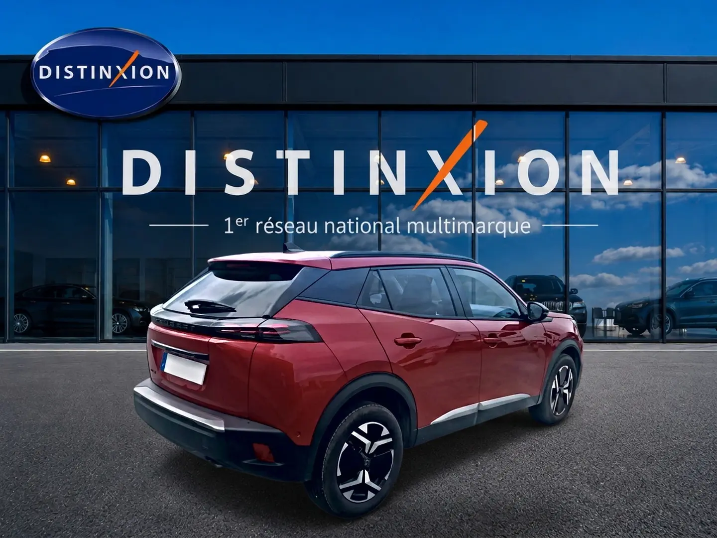 Peugeot 2008 rouge elixir vue 3/4 arrière droit avec jantes alu et toit noir devant vitrine Distinxion.