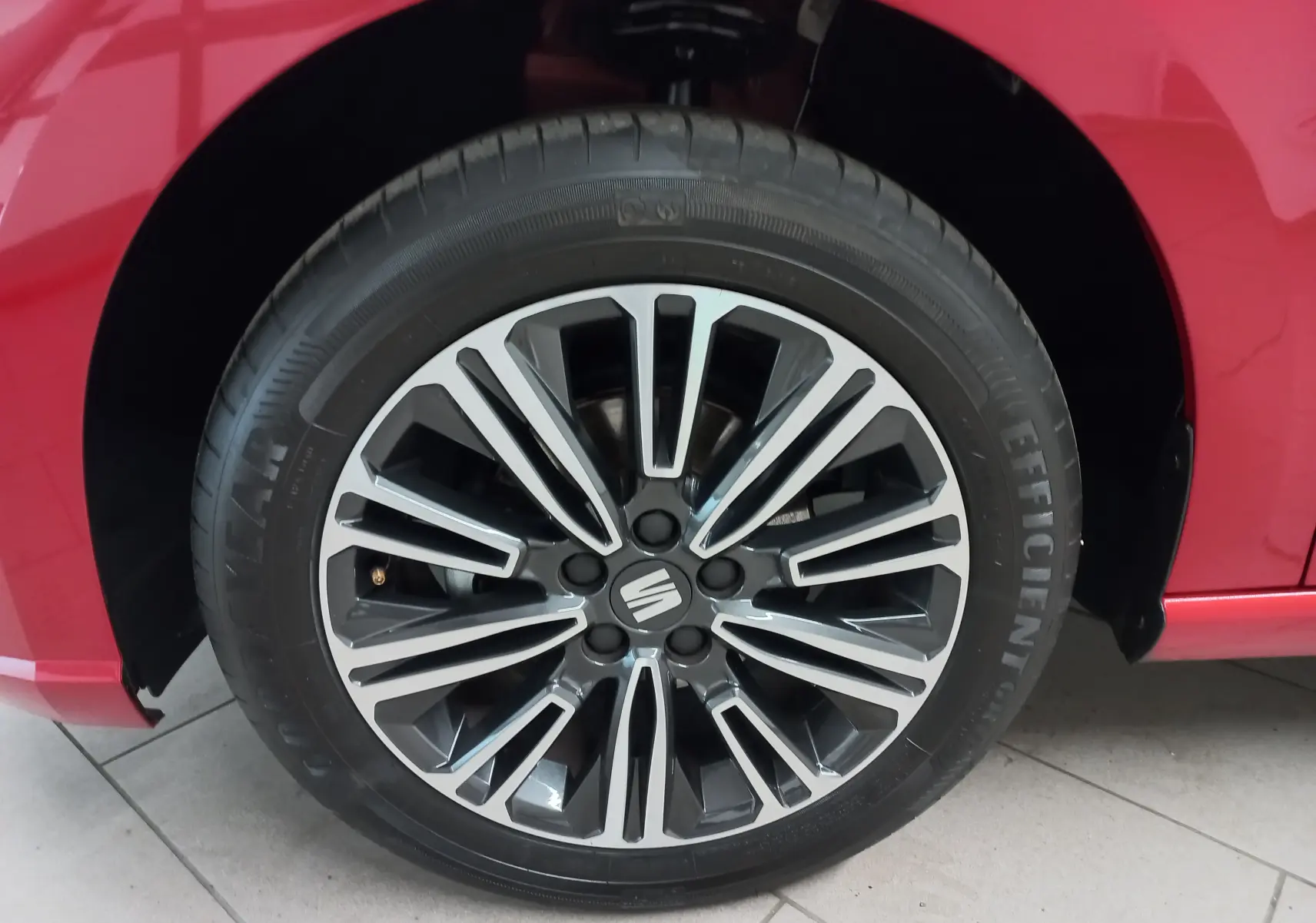 Gros plan sur la roue avant droite d'une SEAT Ibiza 2025 rouge désir avec jante alliage noire et argentée.