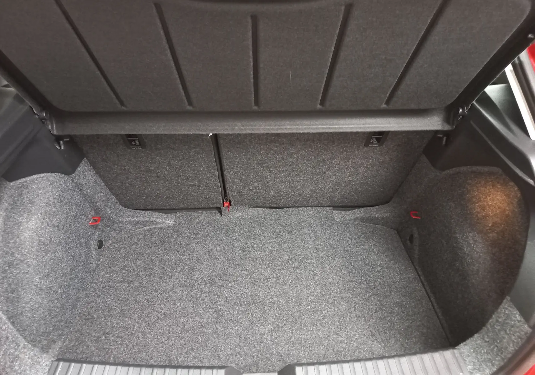 Coffre ouvert de la SEAT Ibiza 2025 rouge désir, vue intérieure montrant le volume et la moquette grise du coffre.