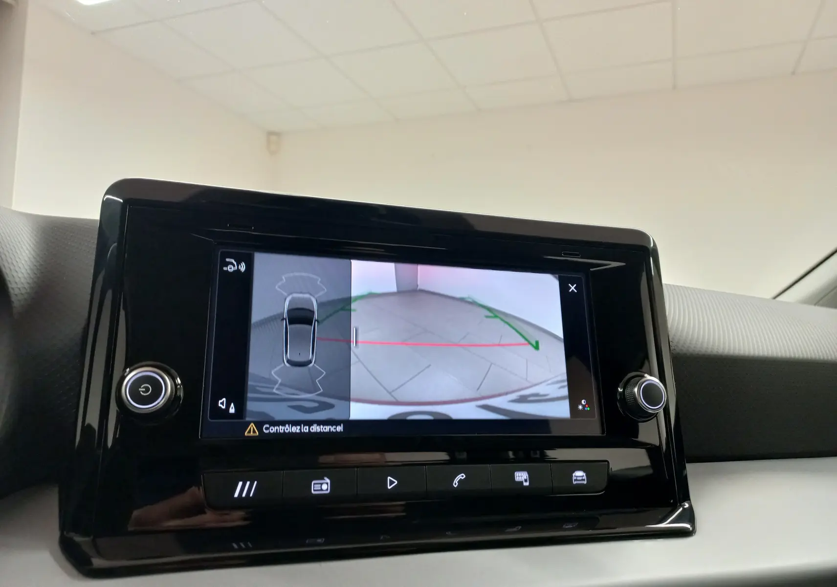 Écran tactile intérieur du SEAT Ibiza 2025 montrant la caméra de recul avec guidage dynamique, entouré de commandes noires brillantes.