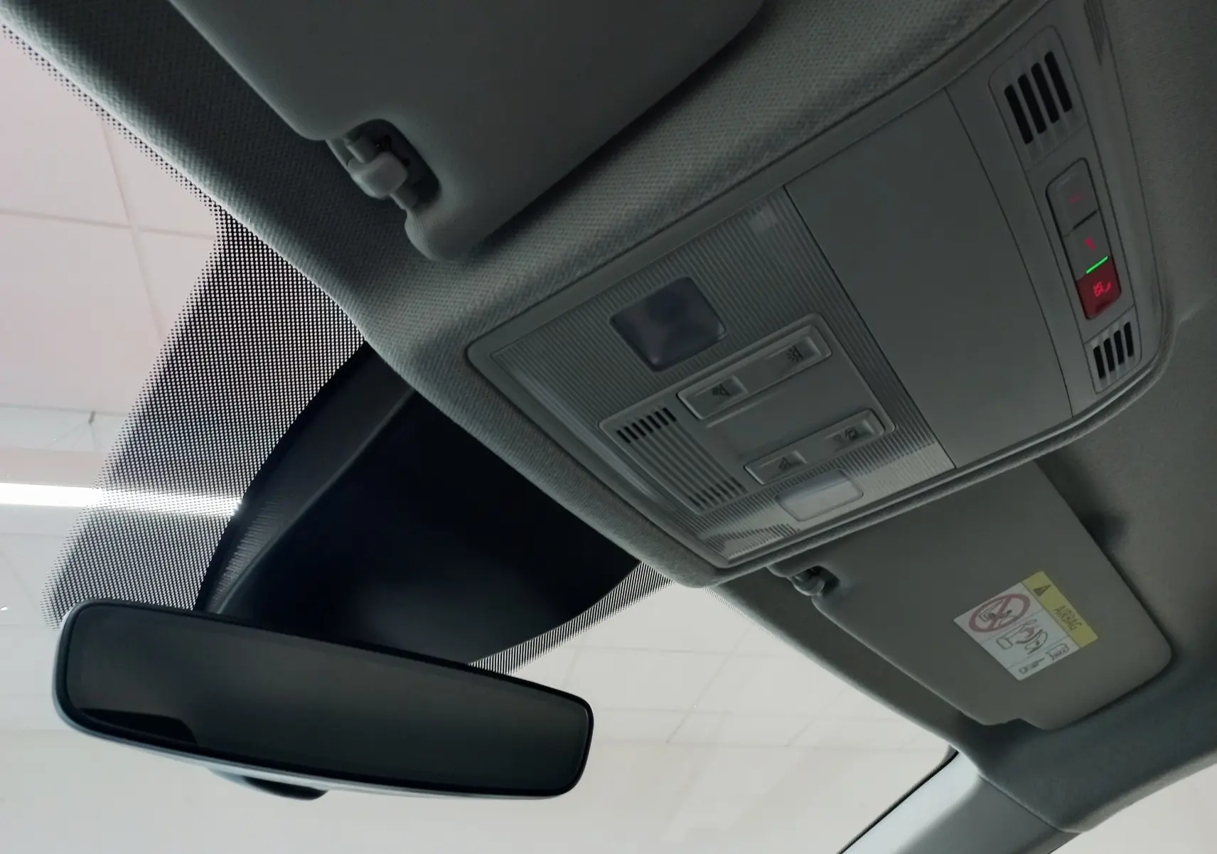 Vue intérieure du plafond avant de la SEAT Ibiza 2025 rouge désir, montrant le rétroviseur et la console de plafonnier avec commandes.