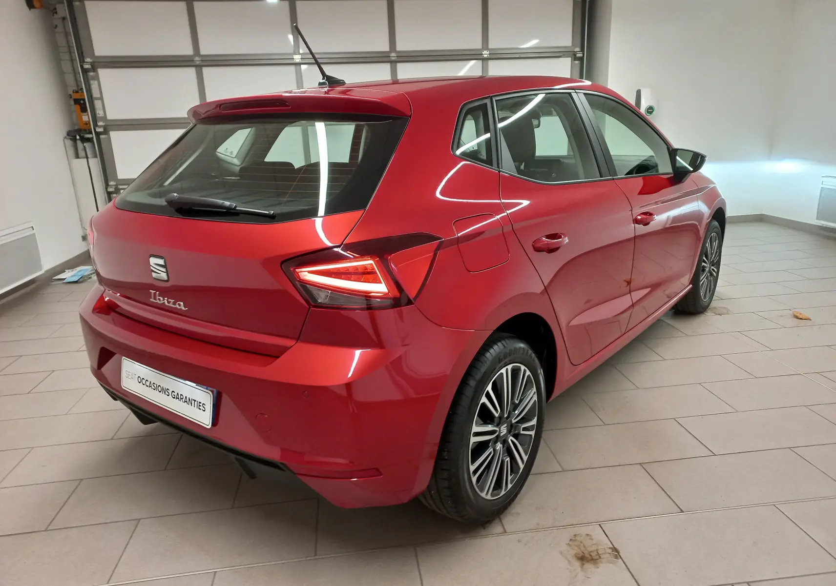 Vue 3/4 arrière droite d'une SEAT Ibiza Rouge Désir 2025 avec feux arrière LED et jantes alliage distinctives.