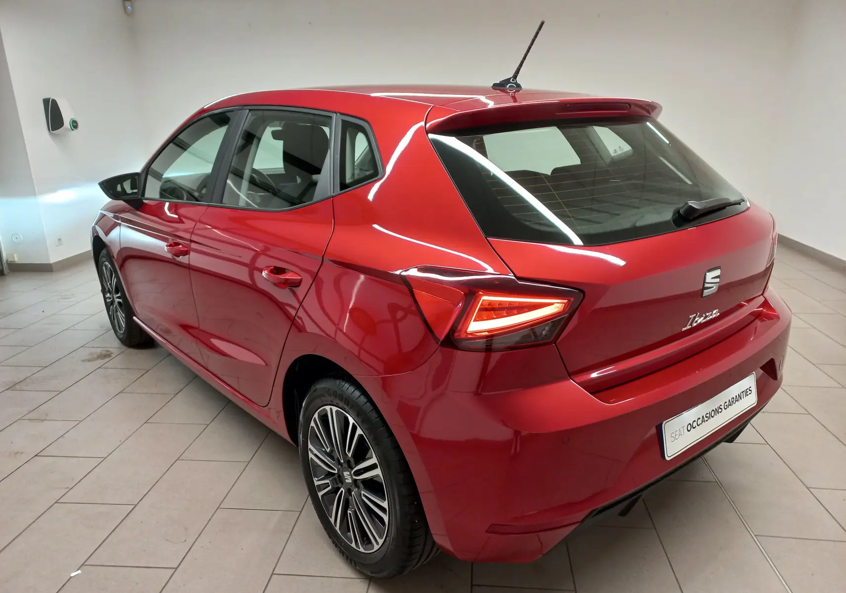 SEAT Ibiza 2025 Rouge Désir vue 3/4 arrière droit, feux LED allumés et jantes alliage distinctives.