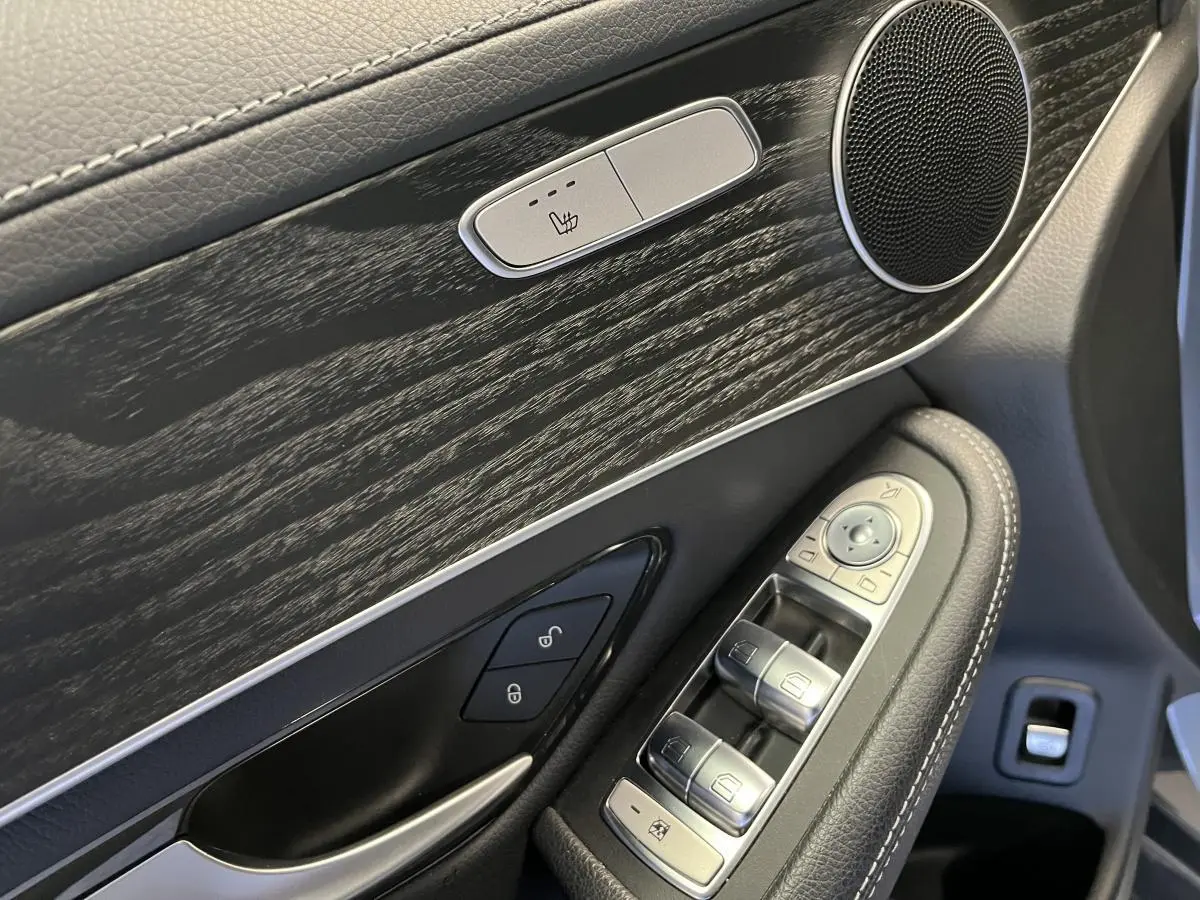 Détail de la porte avant gauche du Mercedes GLC gris, avec commandes des vitres et bouton de siège chauffant.