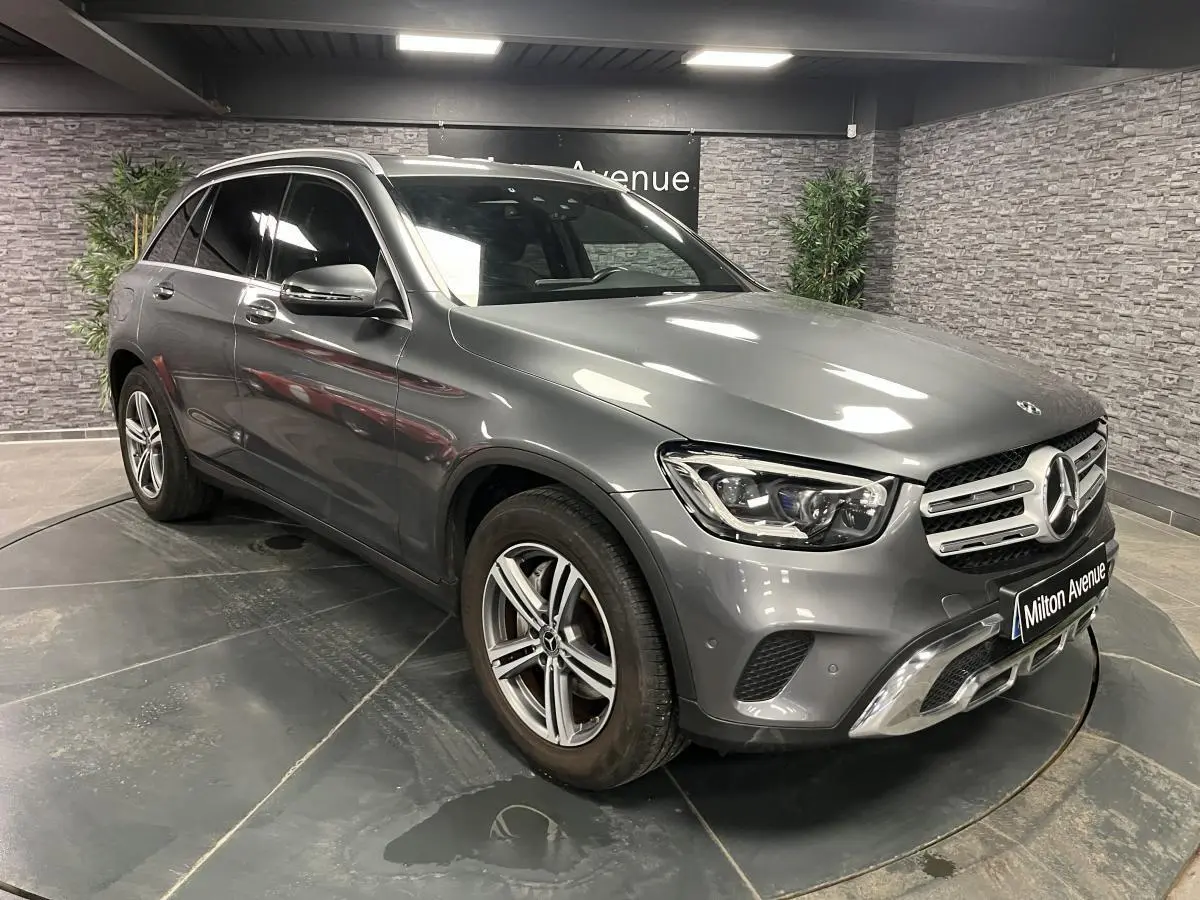 Mercedes GLC 200 4MATIC gris en 3/4 avant droit, avec jantes alliage et calandre chromée en showroom.