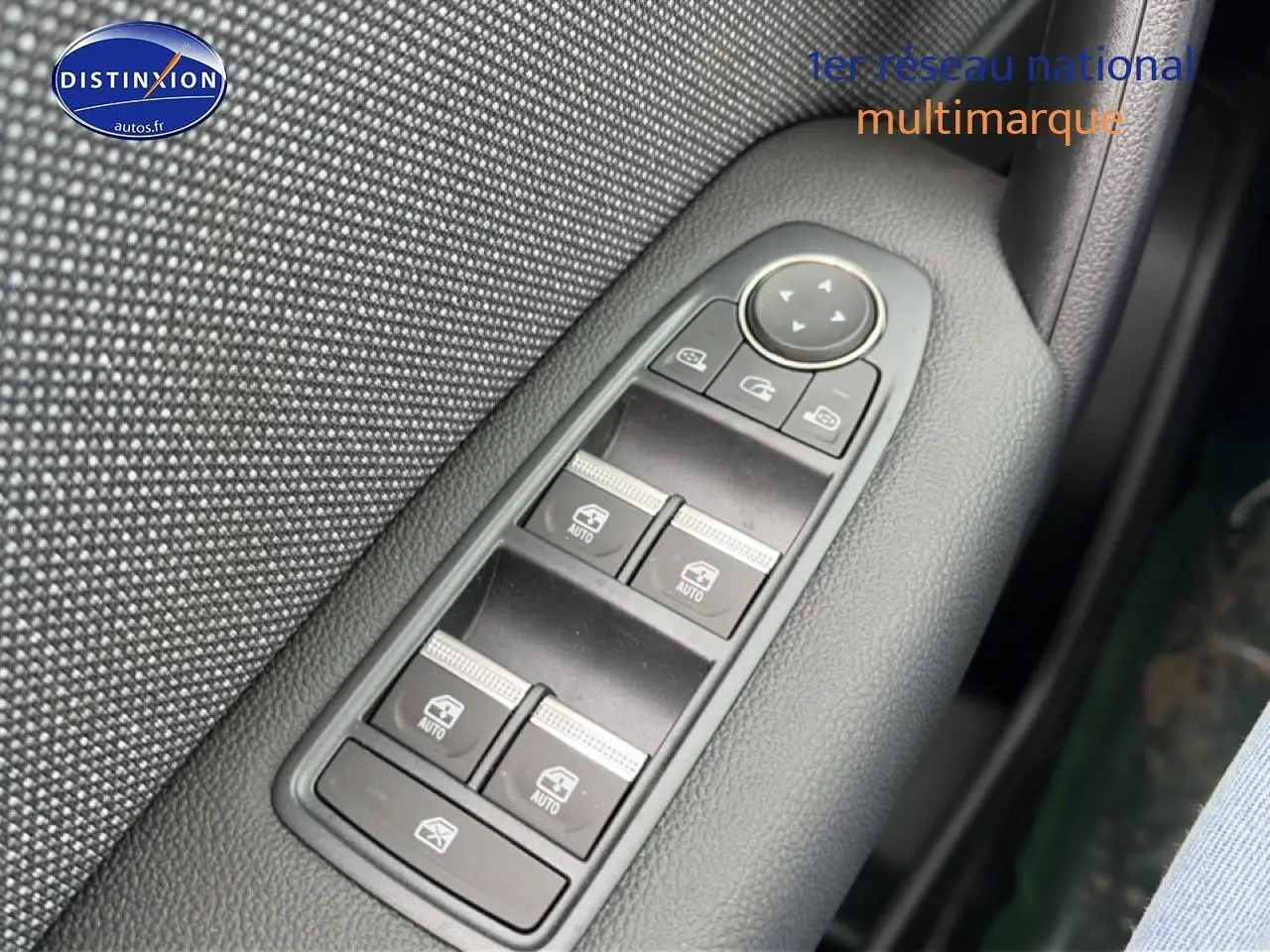 Gros plan sur les commandes des vitres électriques côté gauche dans une finition noire texturée du Renault Symbioz gris schiste.