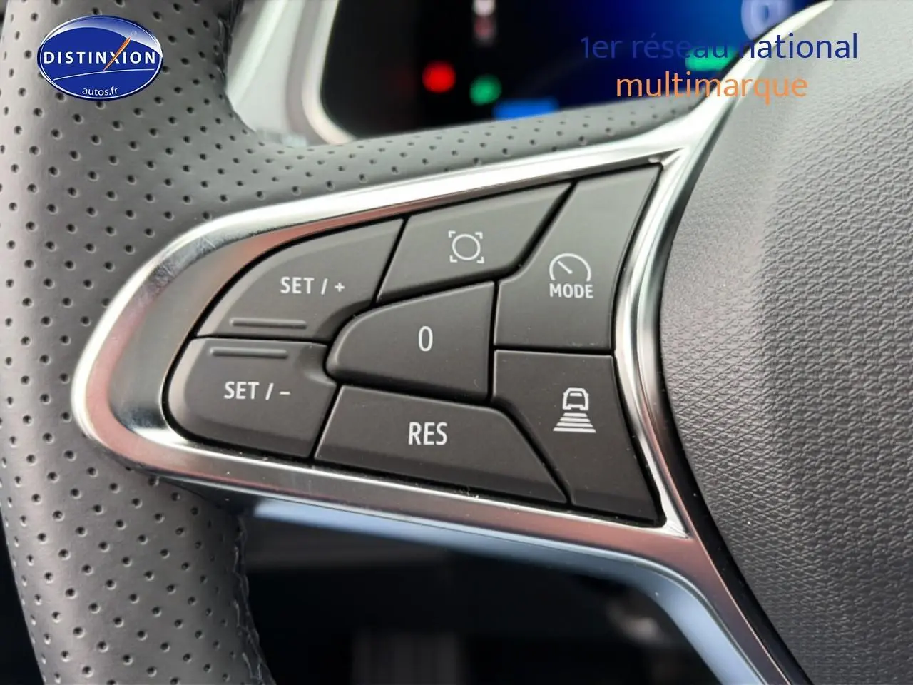 Gros plan sur les commandes multifonctions noires et chrome du volant perforé du Renault Symbioz gris schiste.