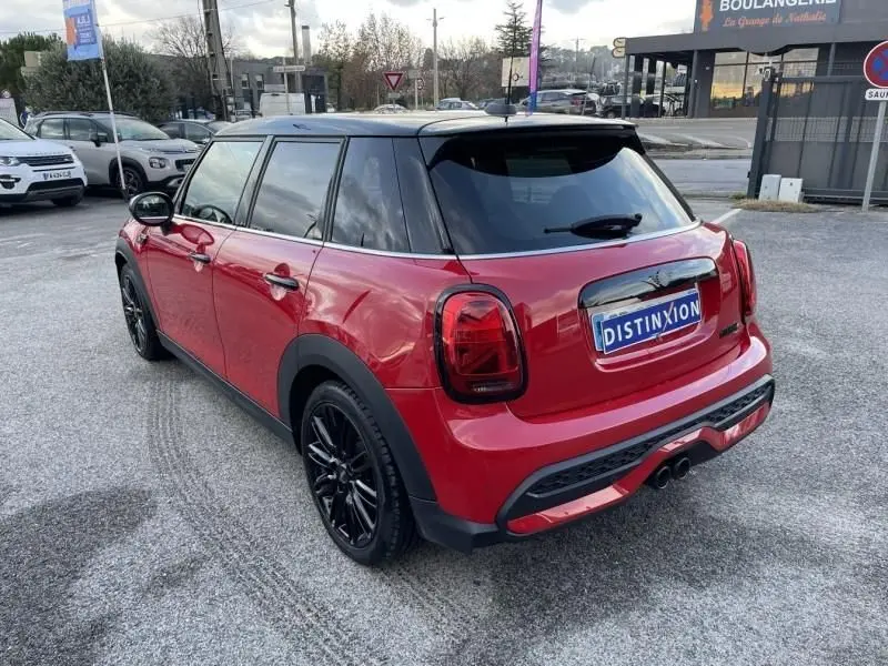 MINI 5 portes Cooper D rouge vue 3/4 arrière droit, toit noir et jantes noires brillantes visibles.