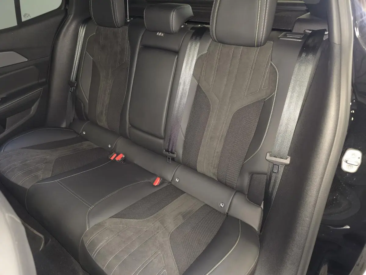 Vue latérale droite de la banquette arrière noire en cuir et tissu du Peugeot 408 1.2i Hybrid GT 2024.