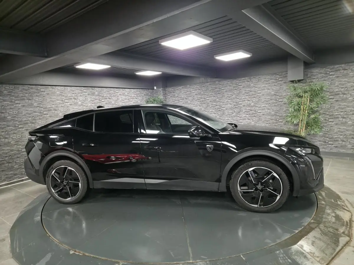 Peugeot 408 noir vue de profil côté gauche, avec jantes alliage 19 pouces et détails noirs brillants.