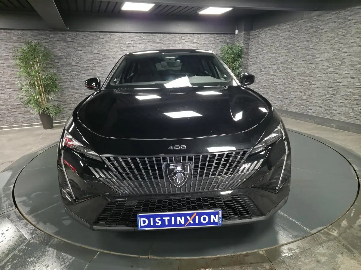 Vue avant d'une Peugeot 408 noire métallisée avec calandre verticale et logo lion central, en showroom.