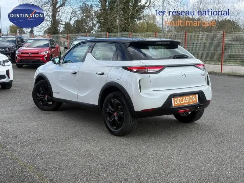 DS3 Crossback blanc perle nacré avec toit noir, vu en 3/4 arrière droit sur parking extérieur.