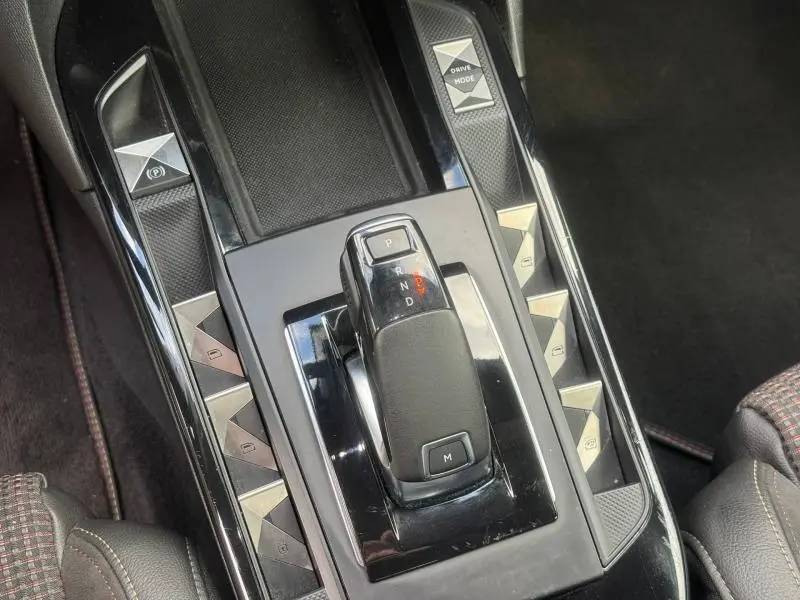 Vue rapprochée de la console centrale noire avec levier de vitesse automatique et boutons triangulaires argentés du DS3 Crossback.