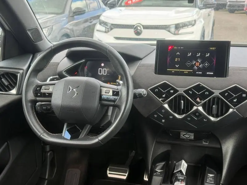 Vue intérieure du tableau de bord et volant du DS3 Crossback blanc perle, avec écran tactile et commandes en losange noirs.