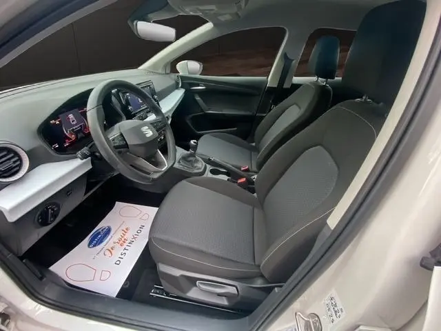 Vue intérieure côté conducteur de la SEAT Ibiza blanche 2023, volant cuir multifonctions et tableau de bord numérique.