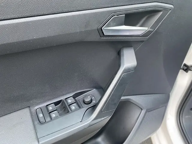 Détail de la porte avant gauche de la SEAT Ibiza blanche 2023, avec commandes des vitres et rétroviseurs électriques.
