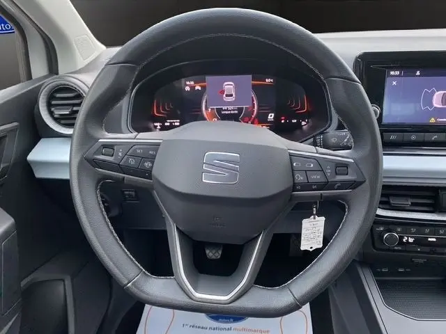 Vue centrée sur le volant cuir multifonctions noir de la SEAT Ibiza 2023, avec tableau de bord digital et écran tactile.