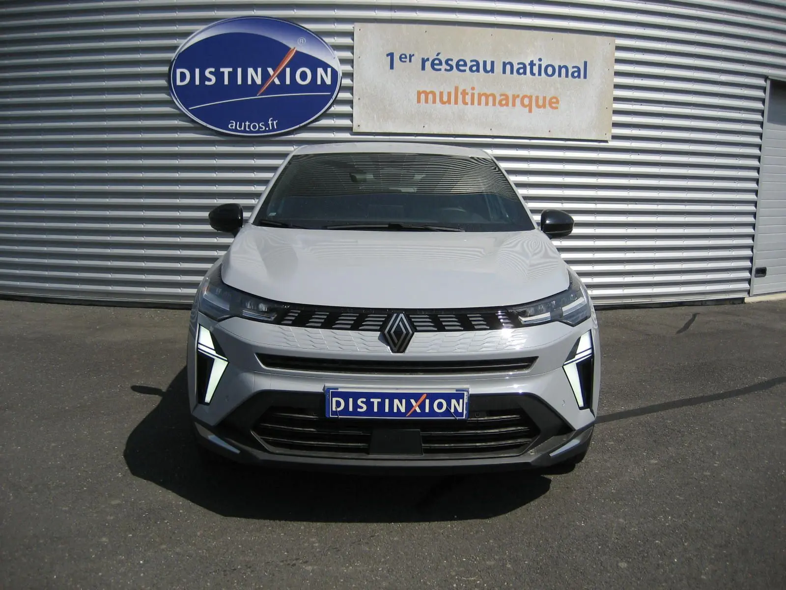 Vue de face du Renault Symbioz gris Rafale 2025 avec feux LED distinctifs et calandre noire brillante.