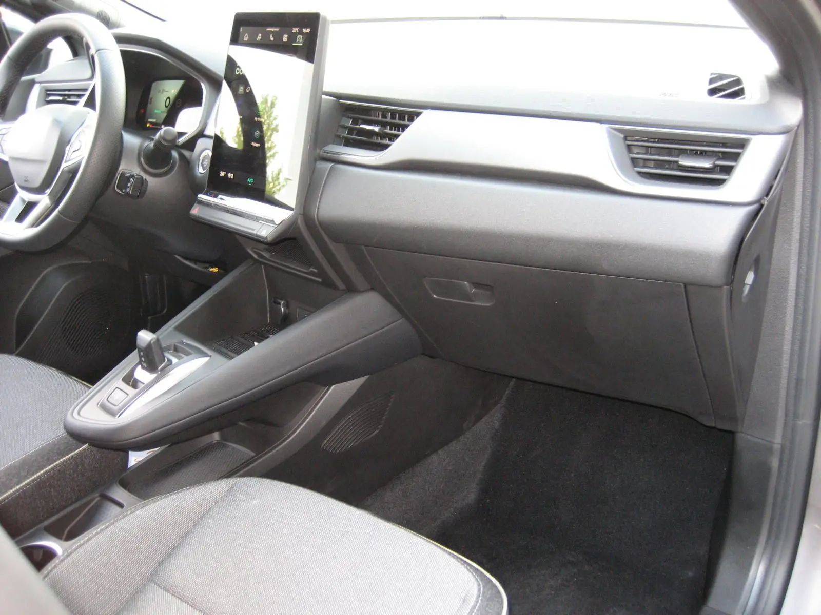 Intérieur avant droit du Renault Symbioz 2025 gris Rafale, avec tableau de bord moderne et écran tactile vertical.