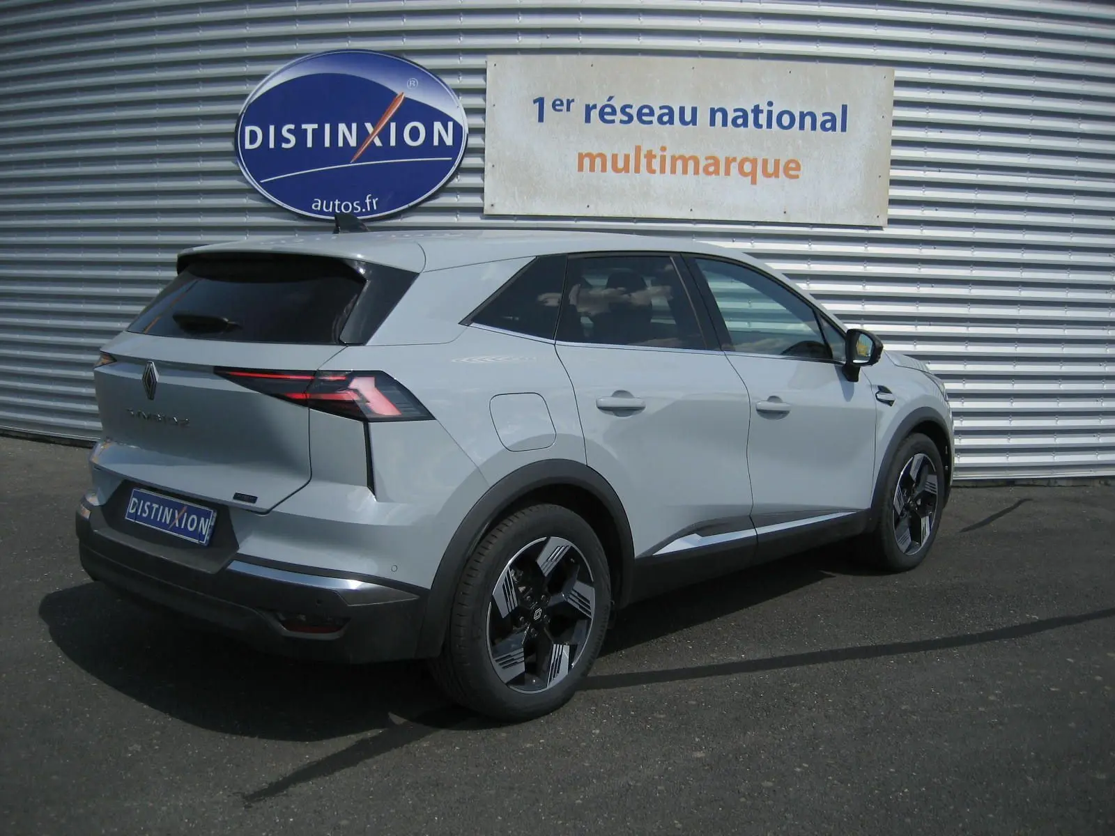 Renault Symbioz gris Rafale vu en 3/4 arrière droit, avec feux arrière LED et jantes bi-ton distinctives.