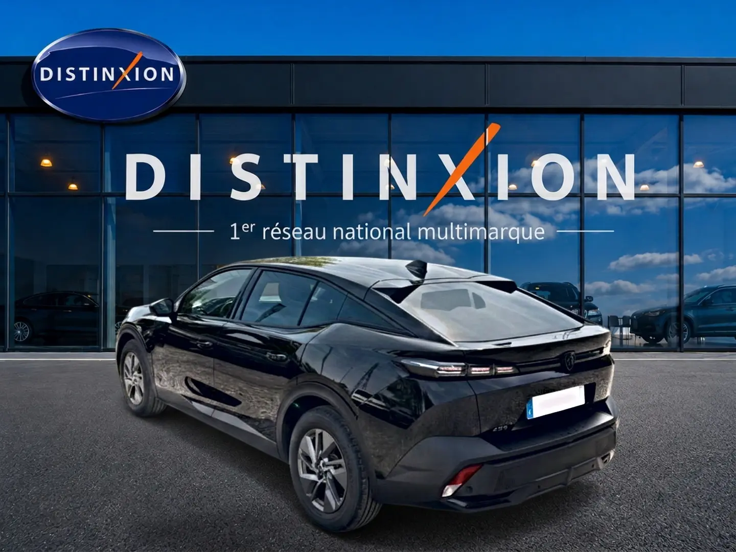 Vue 3/4 arrière droite d'une Peugeot 408 Hybrid 136 allure e-dcs6 noire stationnée devant une vitrine Distinxion.