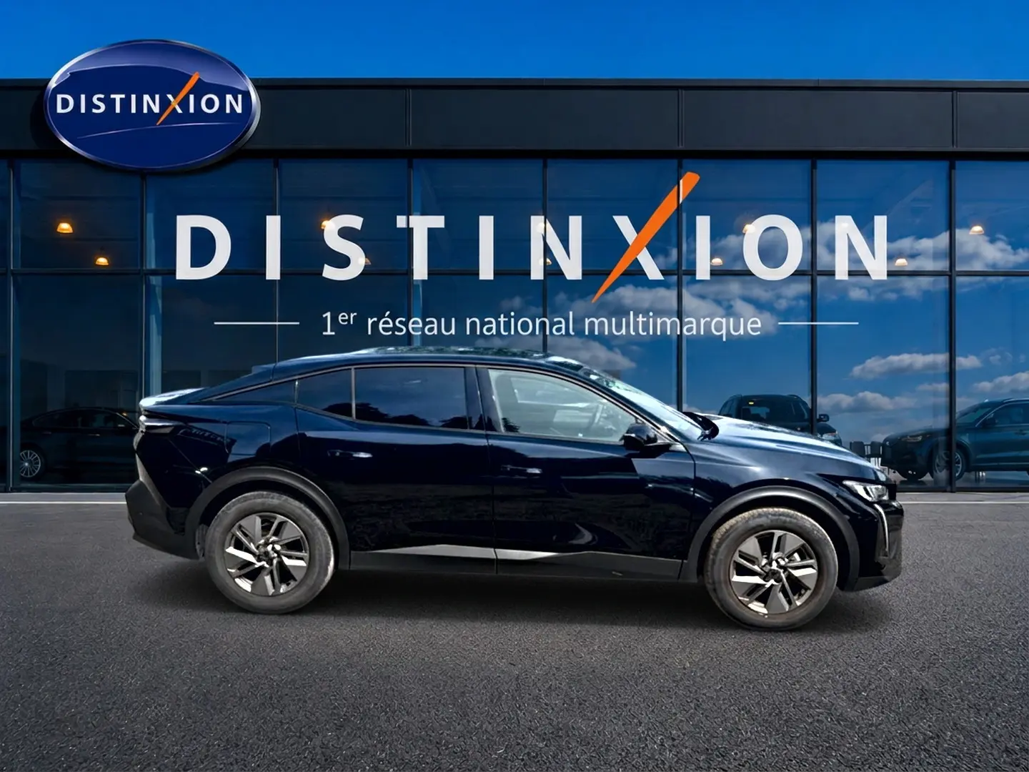 Profil droit d'une Peugeot 408 Hybrid 136 allure e-dcs6 noire, avec jantes alu, devant une vitrine Distinxion.