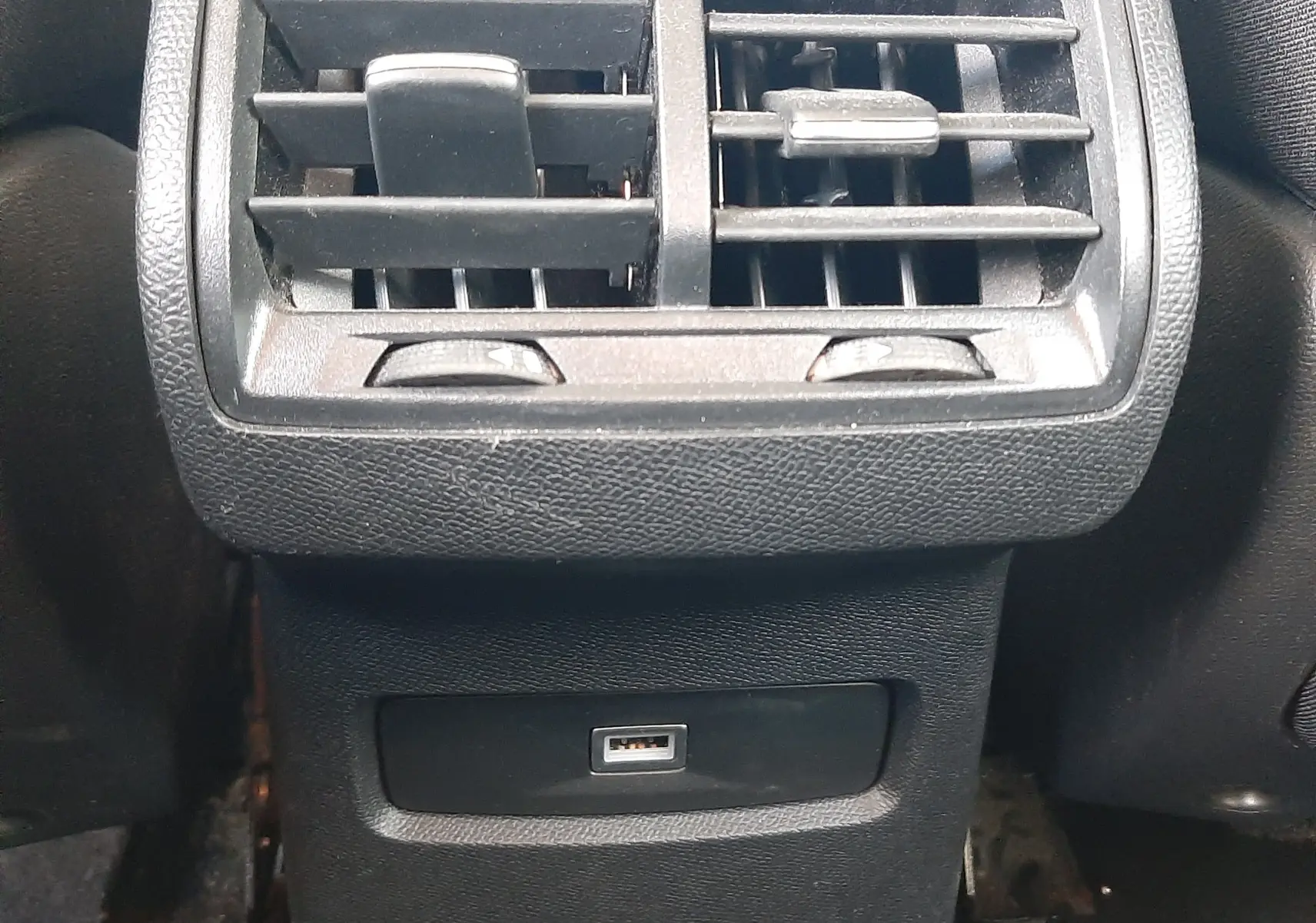 Gros plan sur la sortie d'air arrière noire avec prise USB intégrée dans l'habitacle gris du Citroën C4 2023.