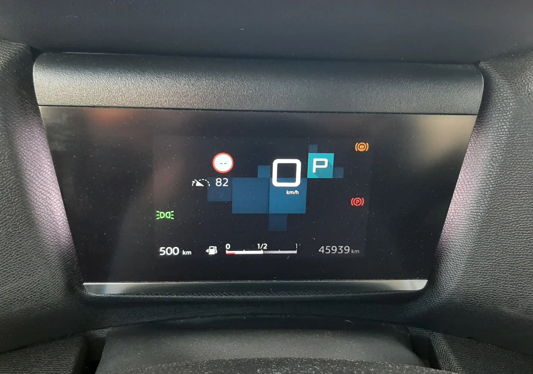 Affichage numérique du tableau de bord de la Citroën C4 gris, montrant la vitesse à 0 km/h et l'indicateur de stationnement.
