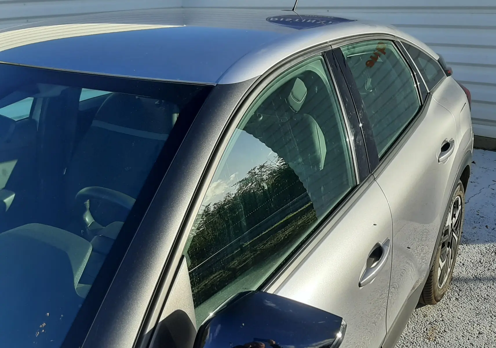 Vue côté gauche avant d'une Citroën C4 gris métallisé 2023 avec rétroviseur noir brillant et jantes alliage.