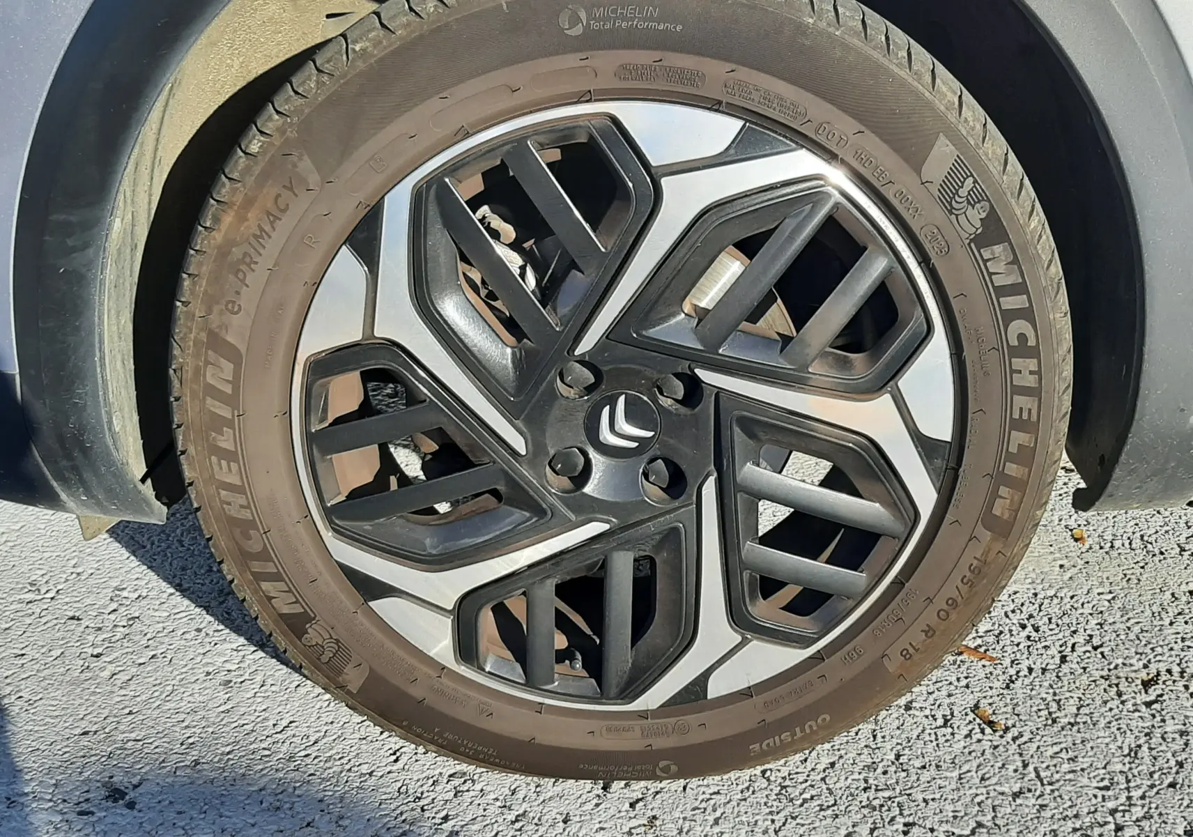 Gros plan sur la roue avant droite grise d'une Citroën C4 2023 avec jante alliage bicolore et pneu Michelin.