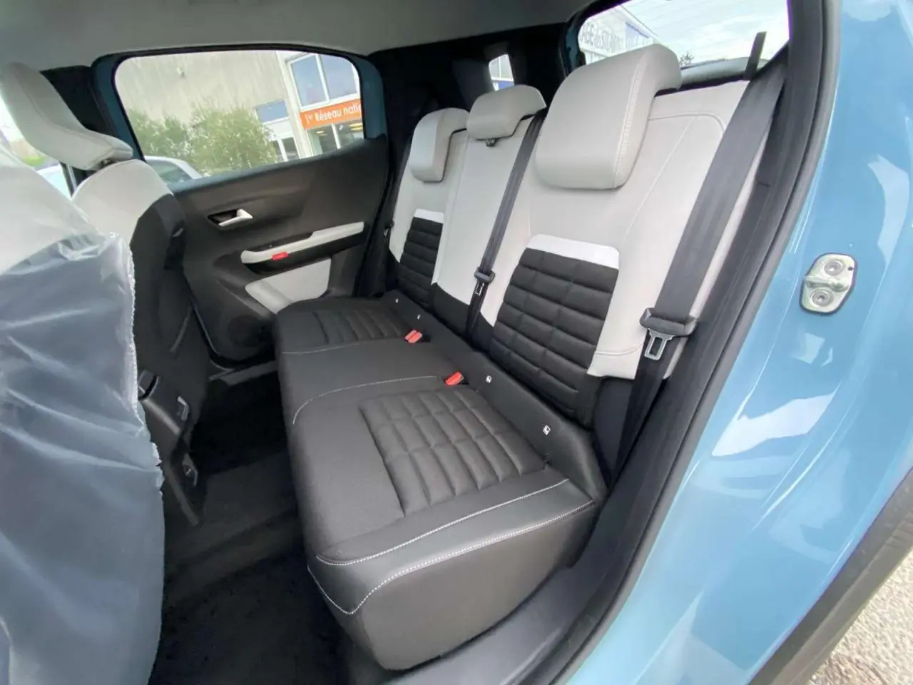 Vue intérieure côté arrière droit du Citroën C3 Aircross bleu Monte Carlo, montrant les sièges arrière bicolores noir et gris.