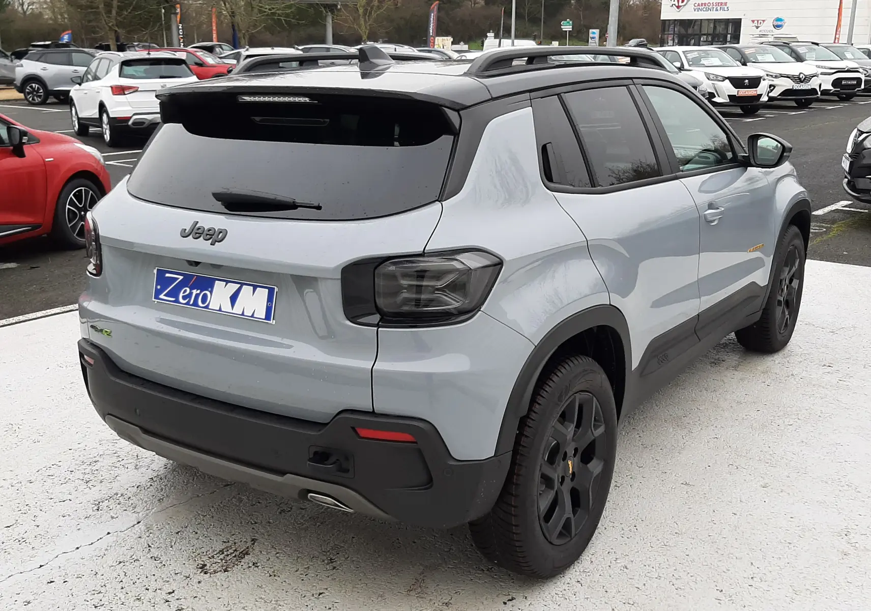 Vue 3/4 arrière droite du Jeep Avenger gris Storm avec toit noir, jantes noires et feux arrière fumés.