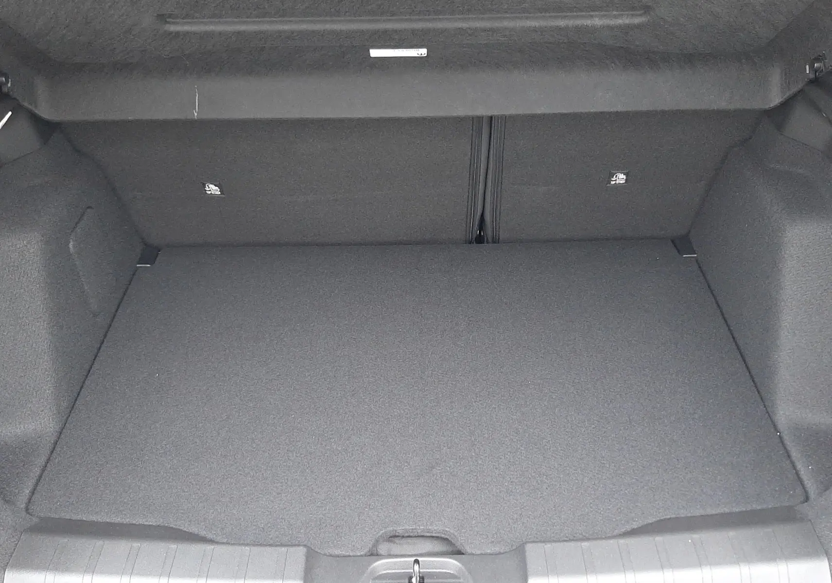 Vue intérieure du coffre spacieux et propre du Jeep Avenger 2025, finition Storm Grey avec toit noir, sans chargement visible.