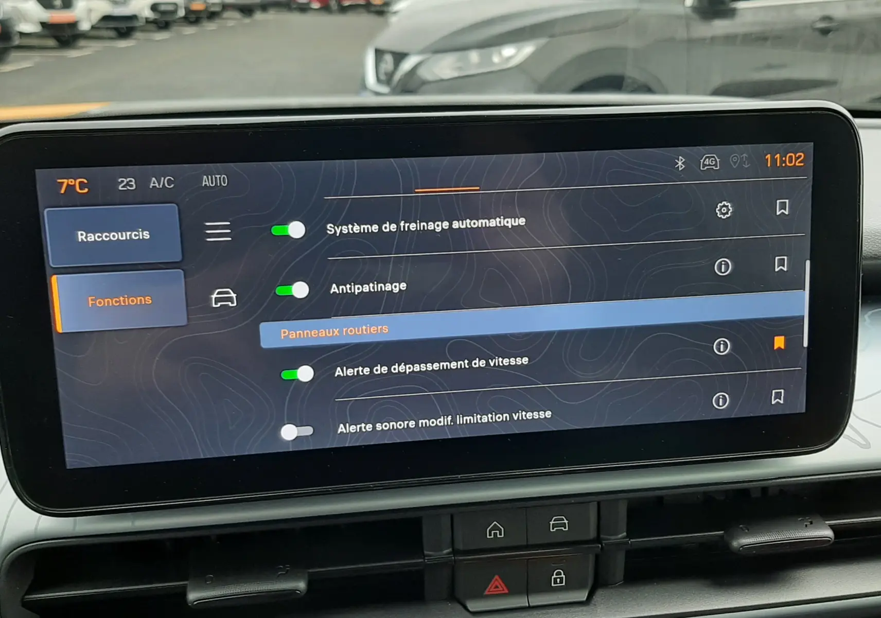 Vue intérieure centrée sur l'écran tactile du Jeep Avenger gris Storm, affichant les réglages d'assistance à la conduite.
