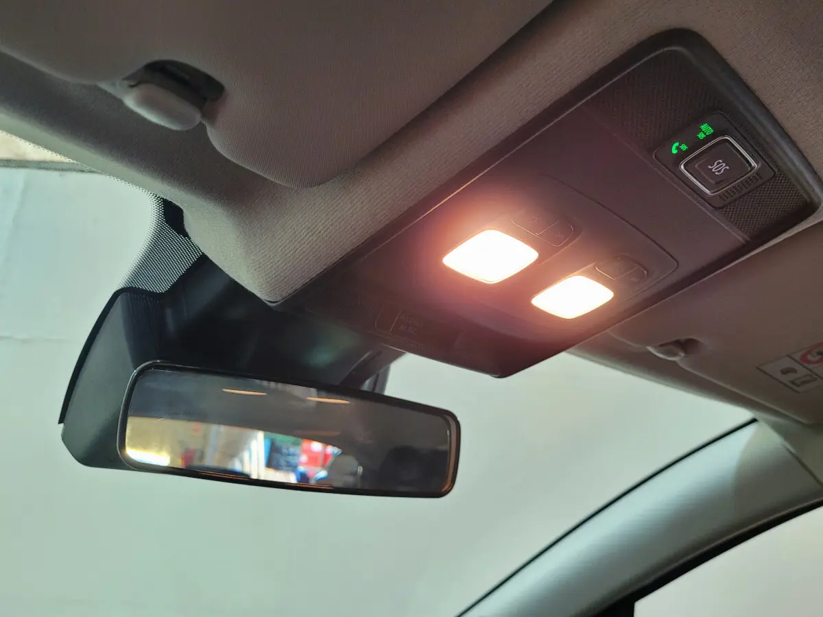 Vue intérieure du rétroviseur central et plafonnier avec éclairage allumé dans une Renault Clio gris foncé 2025.